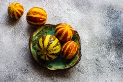 Organic mini melons on grey counter with copy space
