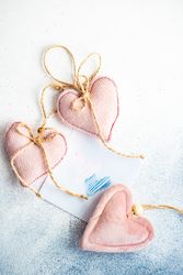Valentine Day holiday card concept with felt pink heart decorations