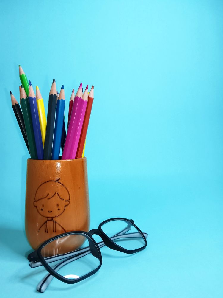 blue background with a container of colored pencils