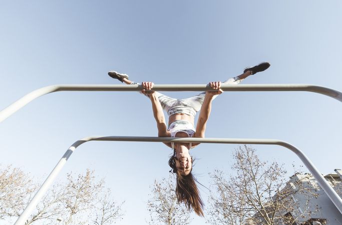 Woman training on parallel bars on street