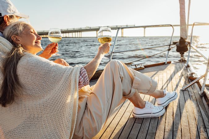 Older couple looking out at front of boat with wine in hand
