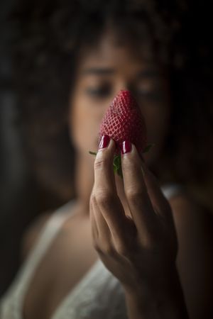 Black woman biting strawberry
