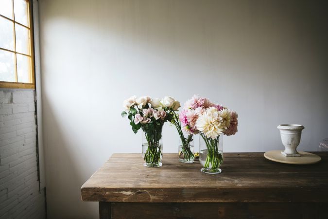 Bunches of flowers in vases on table