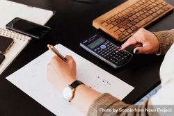 Woman using calculator and sitting at a desk 48Q17b
