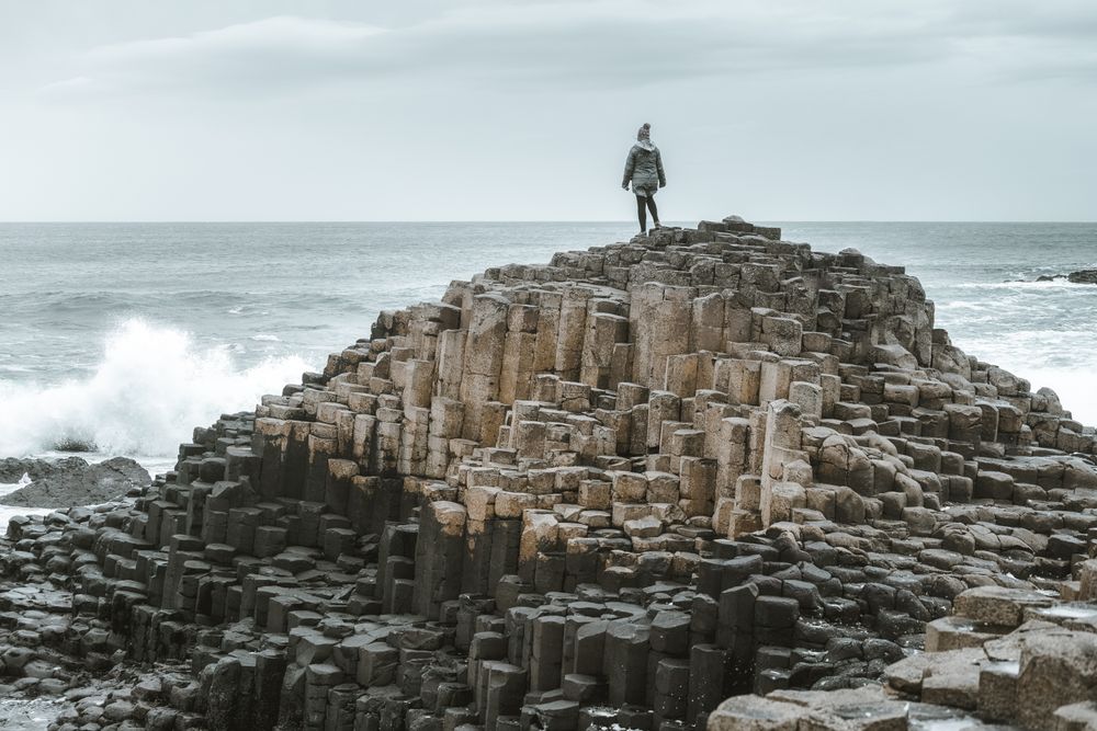 Female standing on cliff and contemplating