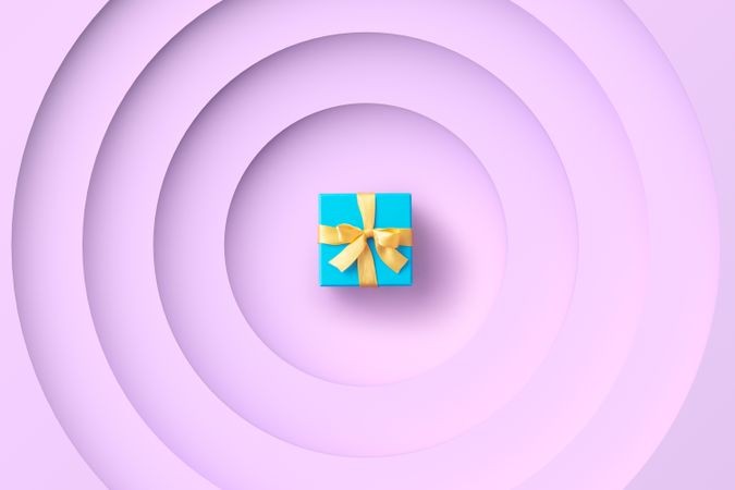 Aqua gift box with yellow ribbon on purple background