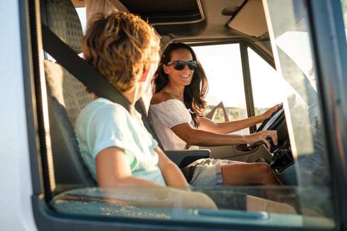 Woman with kid enjoying summer vacation in camper car