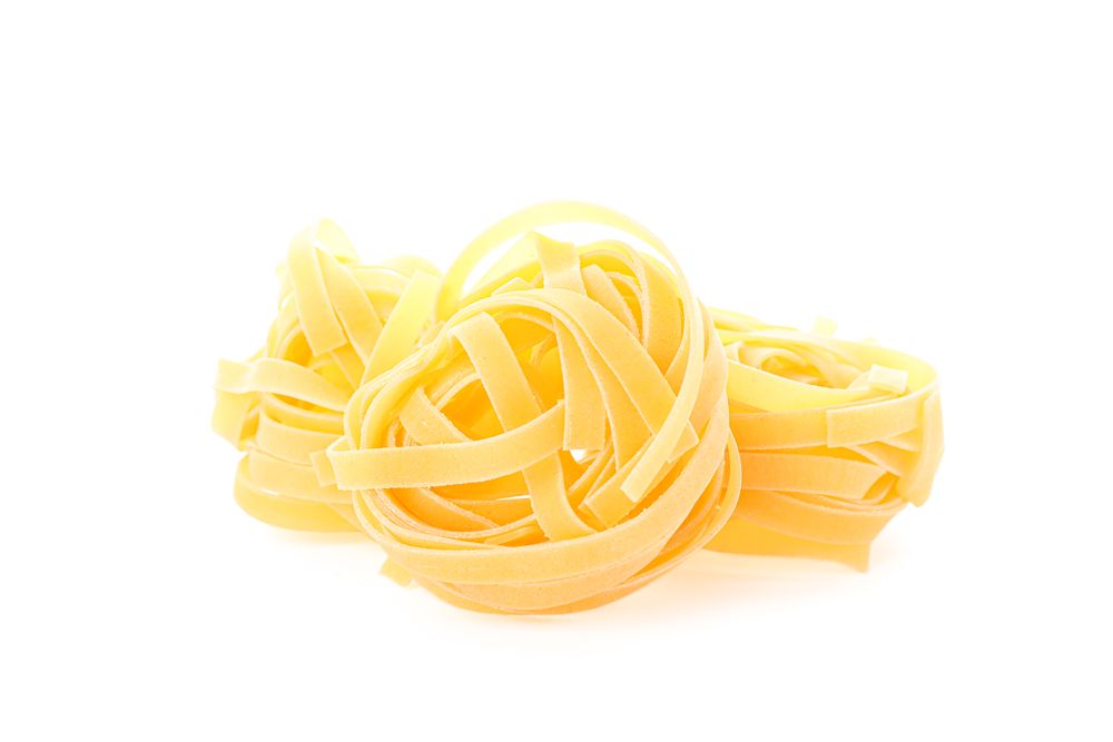 Pasta isolated on light background, closeup. Dry uncooked whole pasta