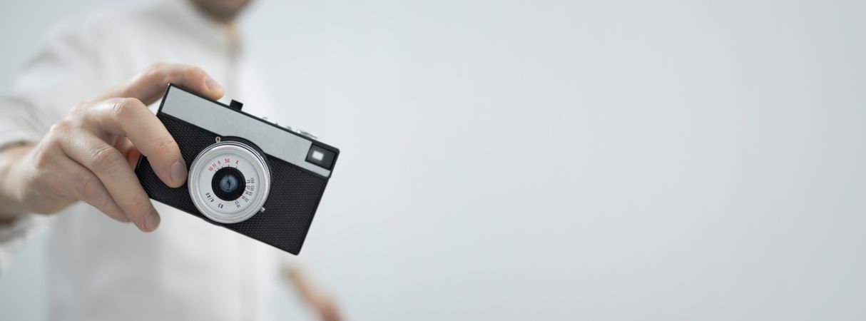 Young man holding retro camera