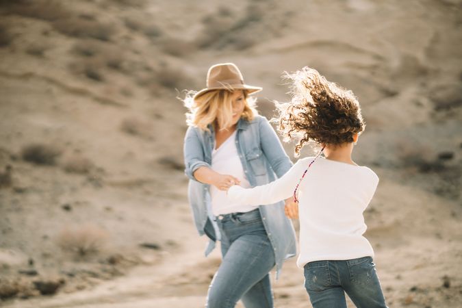 Mother dancing with girl on nature