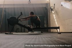 Female athlete using rowing machine 432yGg