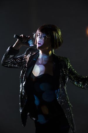 Stylish woman singing on stage
