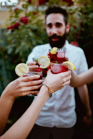 Group of cheerful friends clinking glasses at party