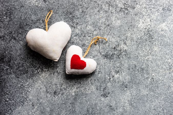 Two felt heart ornaments on grey counter