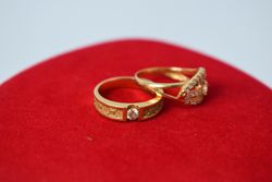 Diamond gold wedding rings on red cloth with copy space