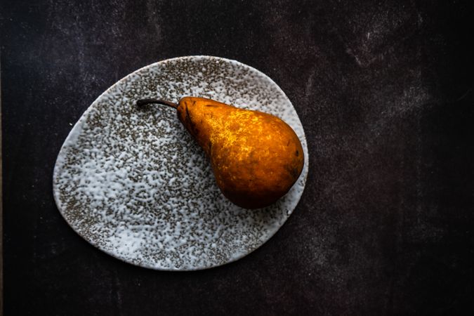 Sweet organic pear fruit on grey stone plate
