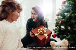 Mother presenting Christmas gift to daughter 5zrwVo