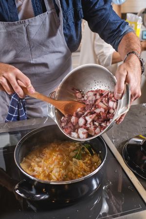 Crop man in apron cooking in kitchen