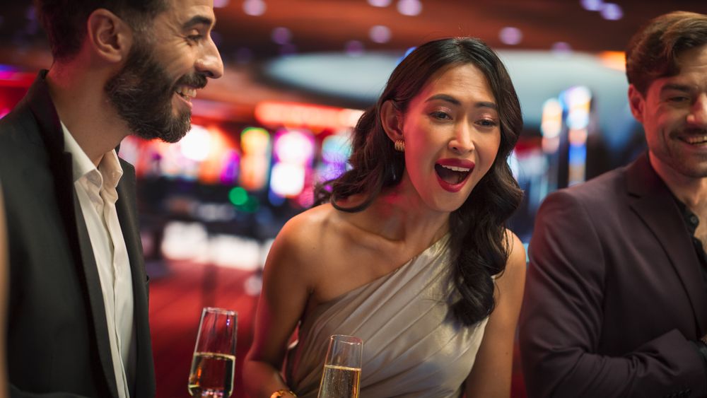 Multiethnic Female Taking Risks in a Casino and Celebrating a Winning Bet with Her Partner.