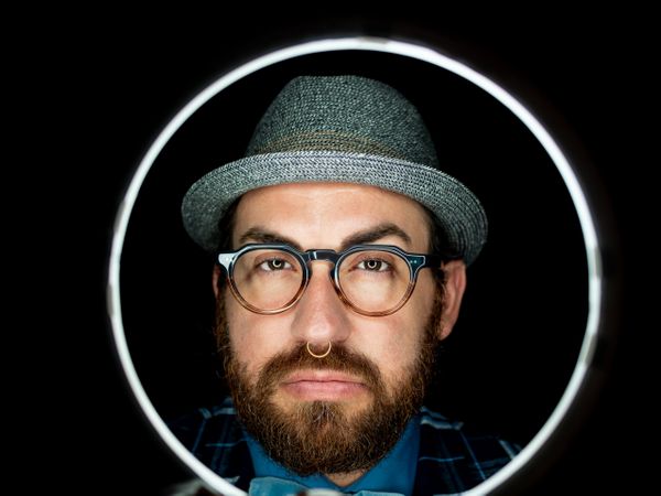 Stylish man in elegant suit behind special circle light