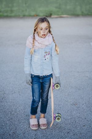 Stylish girl with skateboard on street