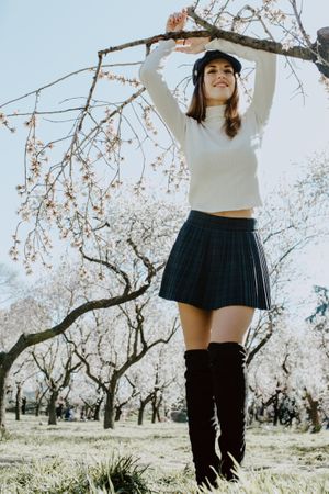 Young happy woman between trees in garden