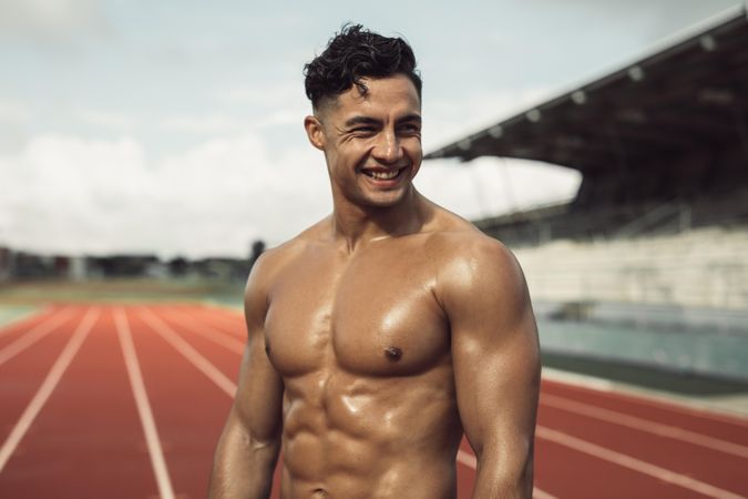 Bare chested man relaxing after workout at race track