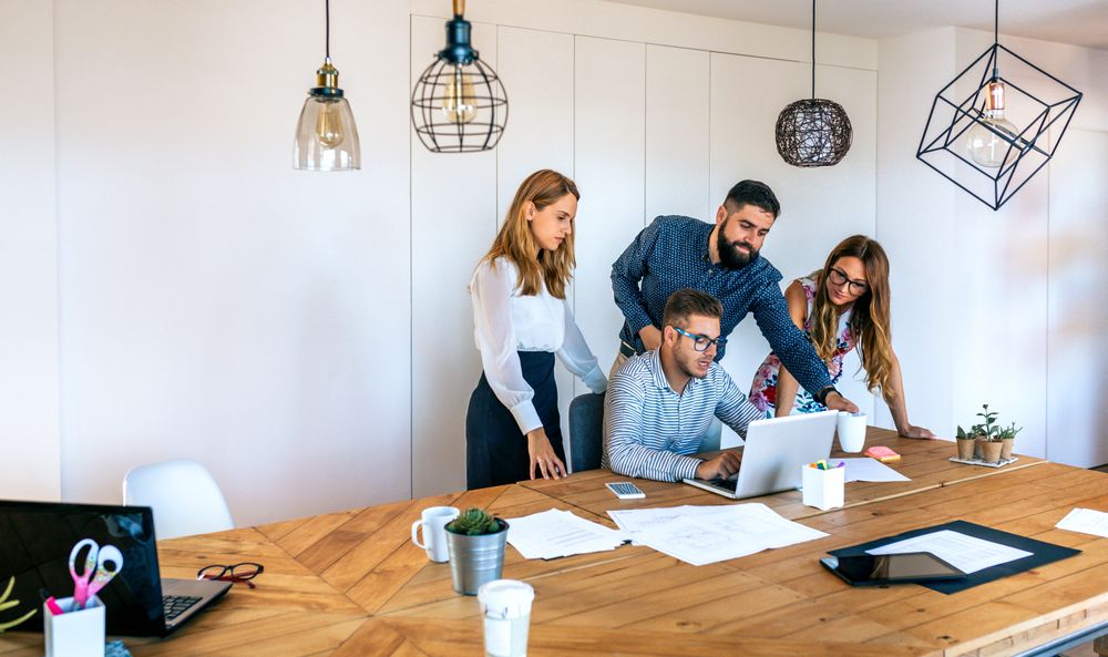 Business people in a meeting standing to review a project