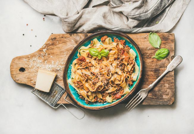 Pasta dinner with minced meat, and cheese on wooden board