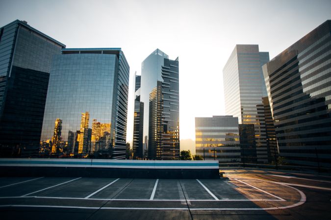 High-rise glass buildings in city at sunset with reflections on them