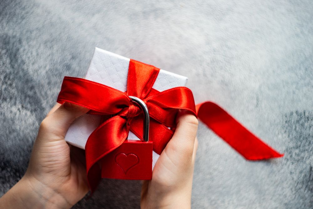 Hands holding present with red padlock