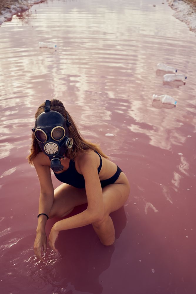 Female in swimwear walking in dirty pool with litter