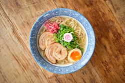 Delicious ramen soup with soft egg and pork meat in bowl