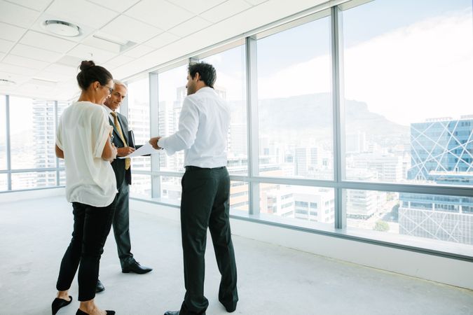 Real estate agent talking with potential clients at new office space