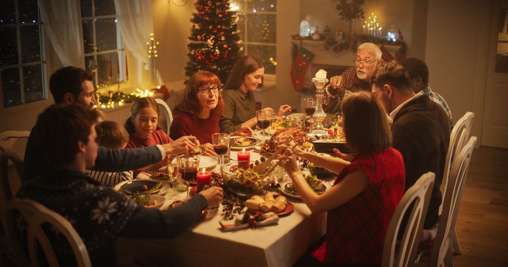 Diverse Group of People, Young and Old, Share a Joyful Christmas Dinner at Home.