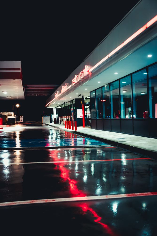 Empty retro gas station with cafe at night after rain