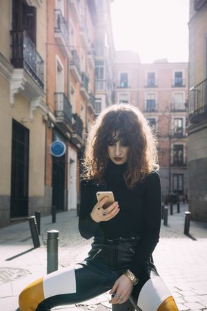 Young woman talking by phone in the street