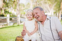 Grandfather and Granddaughter Hugging Outside At The Park