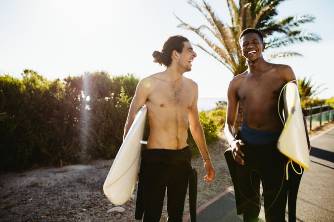 Two male surfers carrying surfboards