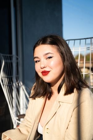Portrait of fashionable young woman with red lipstick looking at camera