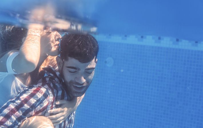 Dressed Couple embracing underwater