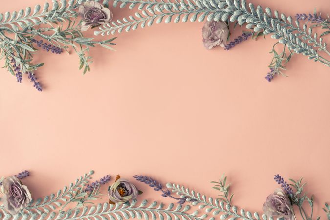 Creative layout made with spring flowers and leaves on pastel pink background