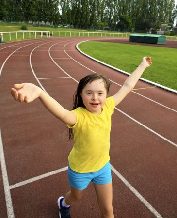 Happy child jogging around running track
