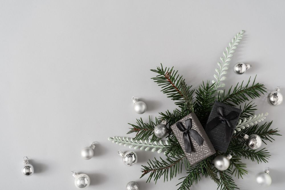 Creative winter nature layout made with fir branches, presents and Christmas baubles