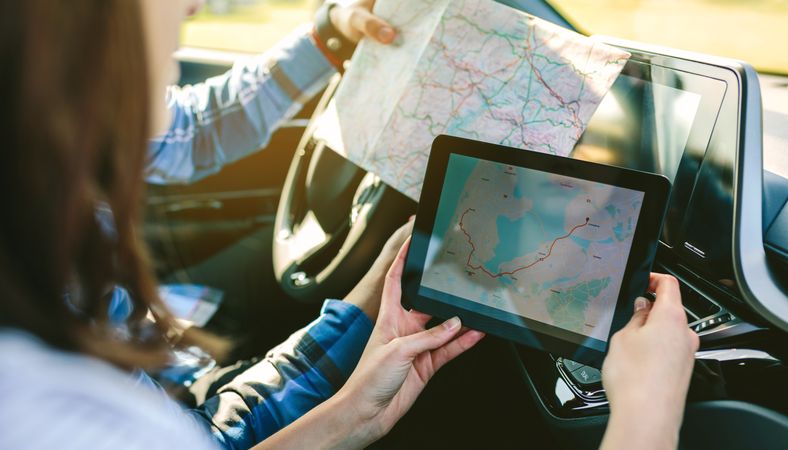 Couple comparing paper map and a gps navigator