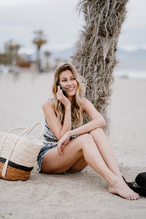 female talking on smartphone on beach