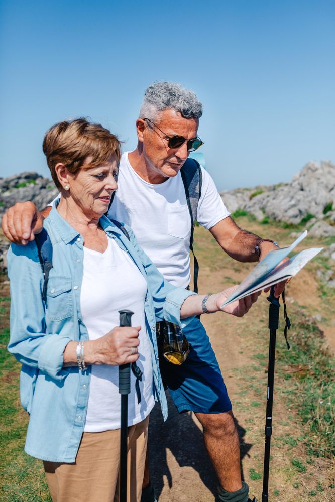 Vertical composition of older couple checking map during a trek