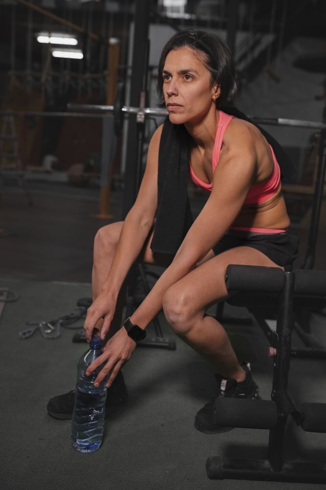 Athletic woman with towel in gym