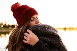 Charming woman in casual wear on shore of lake