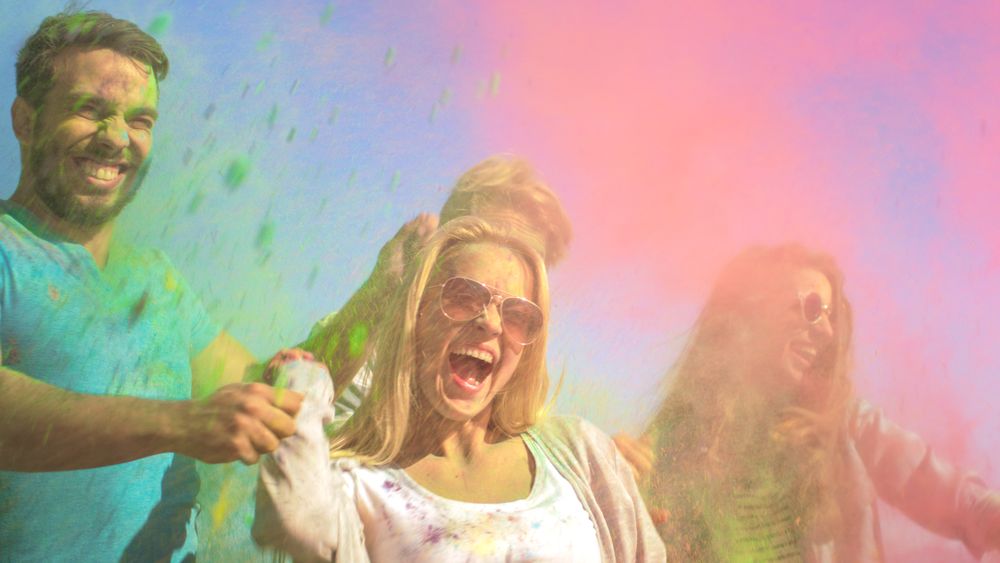 Multi-Ethnic Group of Young People Throw Colorful Powder in Celebration of Holi Festival.